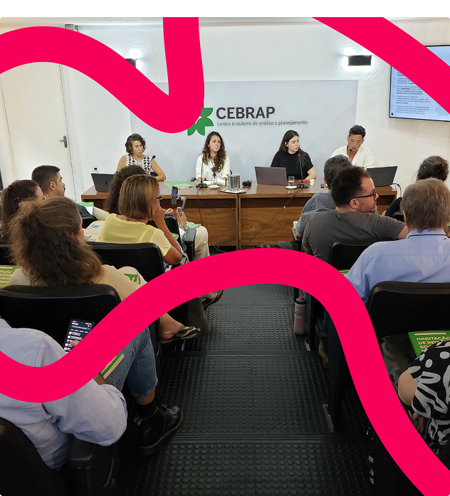 Imagem com Fabiana Tock, coordenadora do Programa Cidades e Desenvolvimento Urbano da Fundação Tide Setubal; Bianca Tavolari, coordenadora do estudo Panorama da Habitação de Interesse Social; e Marcella Puppio e Victor Nisida, pesquisadores que participaram da produção da mesma pesquisa. Pode-se ver também uma plateia no auditório do Cebrap, onde aconteceu o evento - as pessoas seguram exemplares do mesmo estudo.