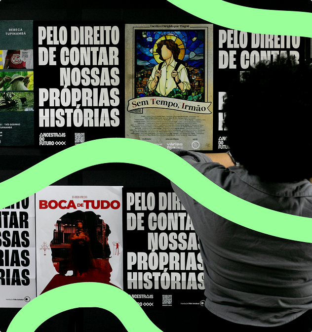 Foto de um mural com cartazes nas cores branca e preta - e com essas mesmas cores invertidas - que contêm a frase Pelo direito de contar nossas histórias. Esses materiais aparecem alternados com os cartazes dos curtas-metragens Fé que Move Rios (Apoena), Sem Tempo, Irmão (Várias Fita Filmes), A Saudade que Habita em Meu Armário (Trivial Filmes) e Boca de Tudo (Ofà Dodún). Aparece à frente dos cartazes uma mulher com cabelo com corte black power e uma camiseta cinza.