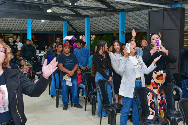 Pessoas em momento de oração durante o Aviva Lapenna no Galpão ZL.