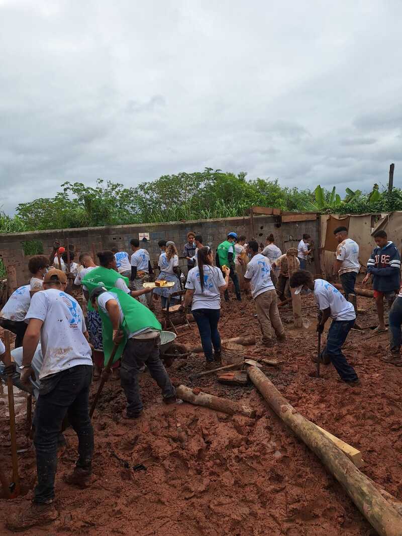 Voluntários analisando terreno lamacento no Baixo Lapena para construção de casas resilientes, alguns usando máscaras cirúrgicas.