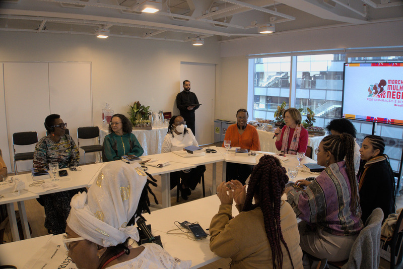 Oyèrónkẹ́ Oyěwùmí, Ana Maria Gonçalves, Sueli Carneiro, Maria Alice Setubal e lideranças da Marcha das Mulheres Negras sentadas à mesa em sala do Itaú Cultural.