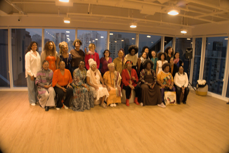 Grupo com Oyèrónkẹ́ Oyěwùmí, Ana Maria Gonçalves, Sueli Carneiro, Maria Alice Setubal e lideranças da Marcha das Mulheres Negras, parte em pé e parte sentada.