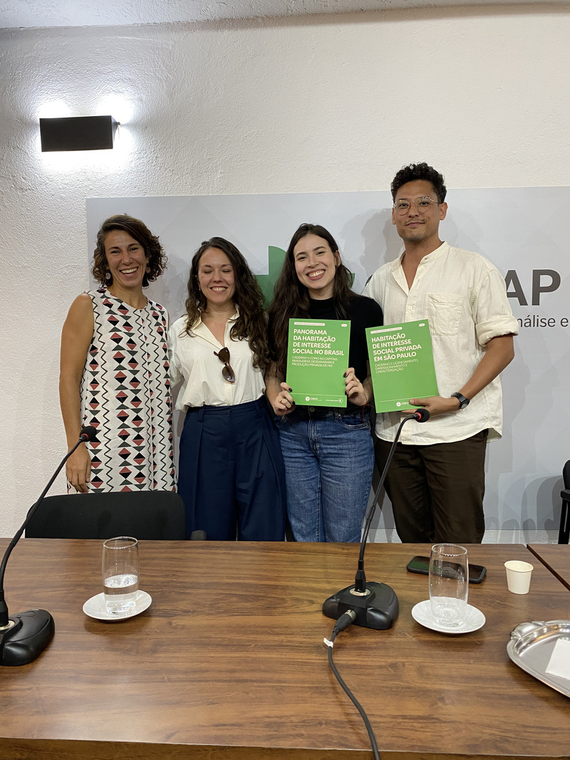 Fabiana Tock, Bianca Tavolari, Marcella Puppio e Victor Nisida apresentando o estudo Panorama da Habitação de Interesse Social, com exemplares da publicação em mãos.