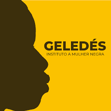 Logo do Geledés - Instituto da Mulher Negra. Aparece à esquerda, dentro de um quadrado amarelo, a silhueta facial de uma mulher. À direita é possível ler o nome da organização.