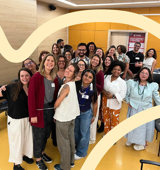 Imagem de pessoas participantes da segunda edição do Edital Territórios Clínicos. Elas aparecem reunidas - algumas próximas à câmera e outras ao fundo - e fizeram poses para aparecer na foto.